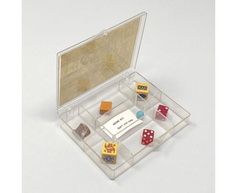 Brecht, George. Games &amp; Puzzles. Transparente Kunststoffbox (zerkratzt) mit 7 Fächern, 7 Utensilien und einem kl. Papiers