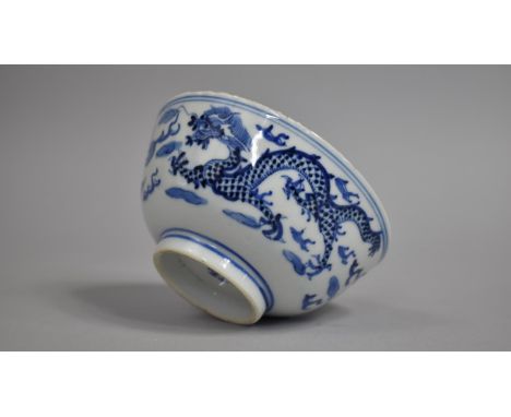 A Chinese Porcelain Blue and White Bowl Decorated with Dragons Chasing Flaming Pearl Amongst Clouds and Scrolls, Four Charact