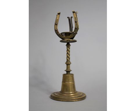 A Late Victorian Brass Novelty Candlestick , the Candle Holder Mounted with upturned Horseshoes on Circular Plinth Base, 27cm