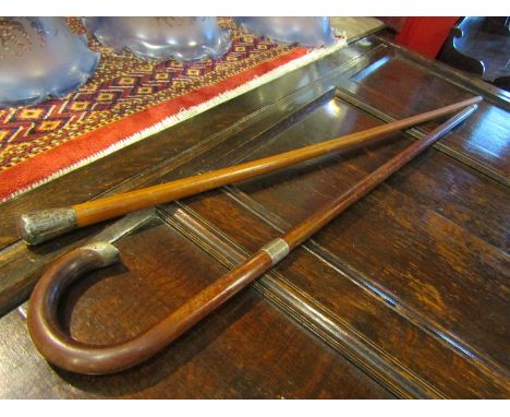 A silver topped walking stick and cane