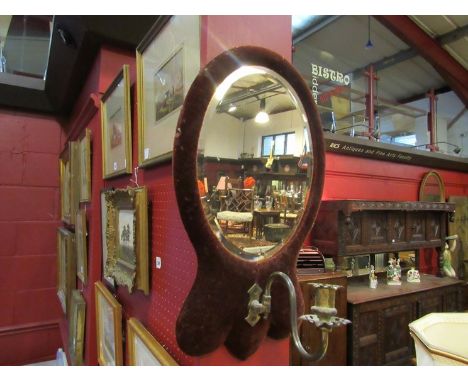 A Victorian oval wall mirror with brass sconce and velvet surround      