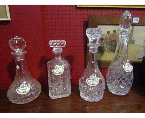 A set of four decanters with stoppers and ceramic labels 
