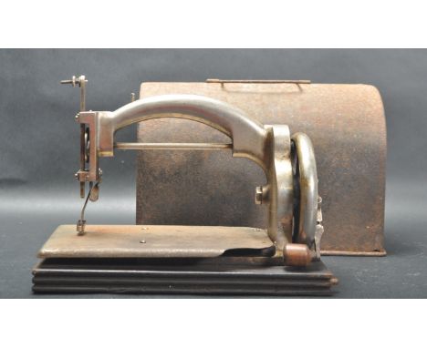 A vintage mid 20th century Ideal miniature sewing machine having a crank handle to the side raised on a wooden plinth base. C