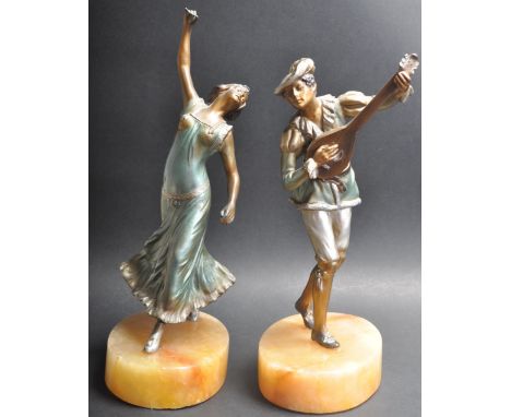 A pair of early 20th century spelter figures depicting a woman dancing and a man playing a lute raised on oval marble bases. 