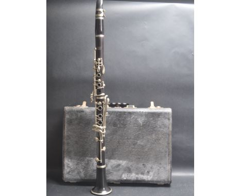 A vintage 20th century clarinet musical instrument by La Fleur having an ebonised shaft with white metal keys and comes with 