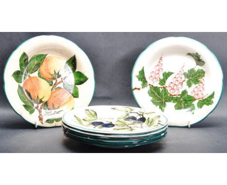 Wemyss for Thomas Goode. A collection of eight ceramic porcelain plates with green scalloped edges and decorated with fruits,