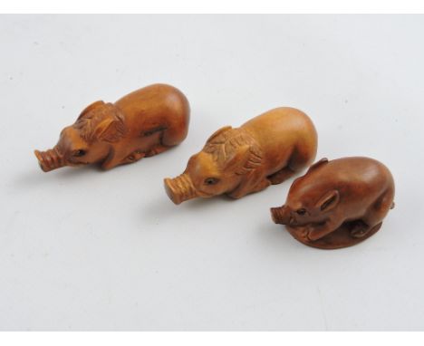 Three Chinese hardwood netsuke, modelled as pigs.