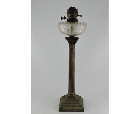 A late Victorian table lamp, with a clear cut glass oil reservoir on an electro plated Corinthian column support with a squar