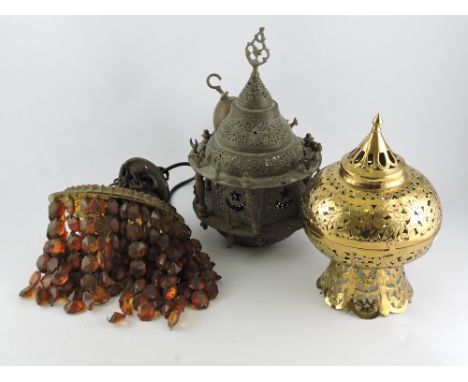 A North African brass hanging ceiling light, pierced with mythical creatures, crescents and stars; together with another pier