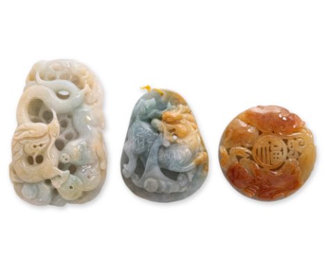 A GROUP OF THREE BURMESE JADEITE PENDANTS
Comprising a green and pale-russet dragon and pig form pendant with double coin bac