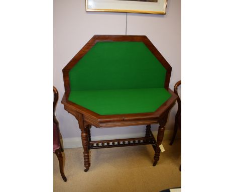 A Victorian walnut octagonal turnover top card table, 107cms wide.