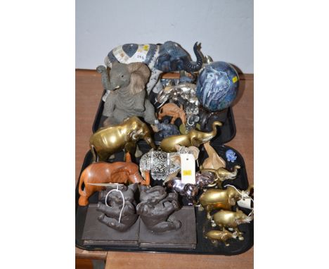 Elephant ornaments of various designs in brass, wood and ceramic; and a pair of book ends in the form of elephants.