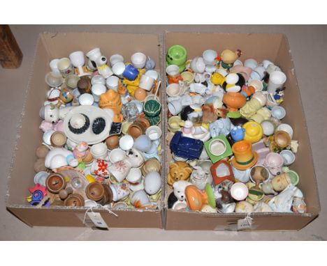 Ceramic and turned wooden egg cups, by various makers, in two boxes.