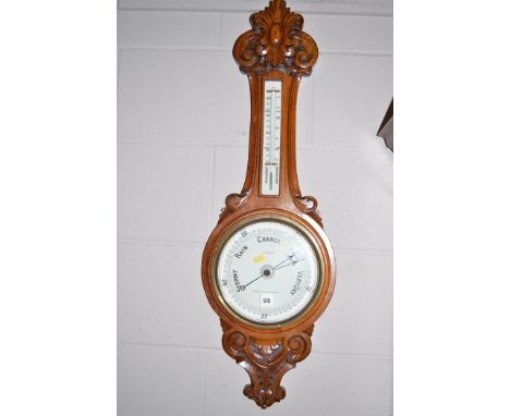 Aneroid barometer and thermometer in carved oak case.