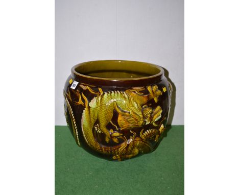 A large ceramic jardiniere, by Bretby pattern No.734 with raised dragon decoration on brown glazed ground.