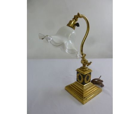 A brass decorative desk lamp, circa 1900 with glass shade