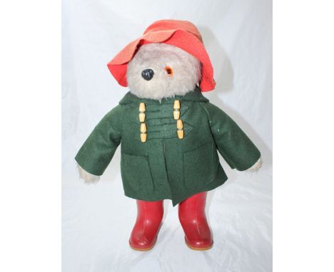 A 1974 Paddington Bear stuffed toy, design 957892, in green duffel coat, red felt hat and Dunlop Wellington boots, approximat