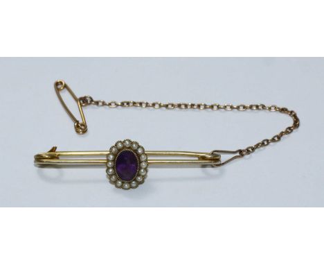 A yellow metal brooch with oval amethyst coloured stone, surrounded by small seed pearls, gross weight 3.4g