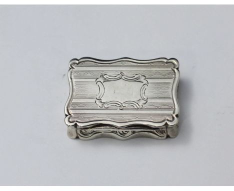 A Victorian silver and silver-gilt vinaigrette, of serpentine-rectangular form with engine-turned top and bottom, pierced gri