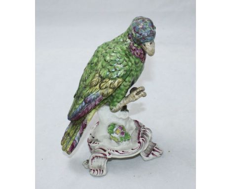 A mid-18th century soft paste porcelain model of a parrot on Rococo base, polychrome enamels, no marks, broken and repaired i