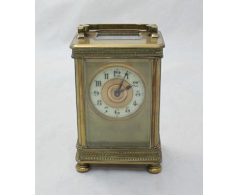 A brass carriage clock in rectangular five glass case, the white chapter ring with Arabic numerals denoting hours, exposed pl