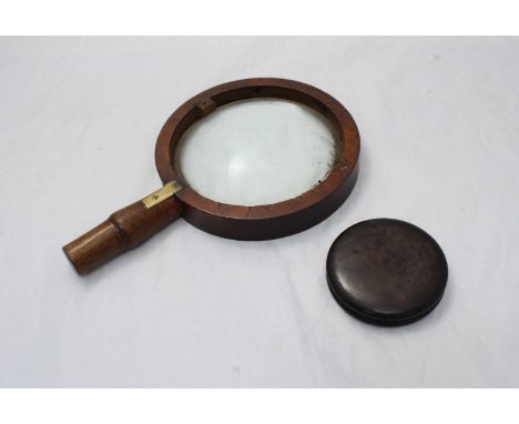 A plain circular burr wood snuff box, 8cm diameter, together with a wooden magnifying glass.