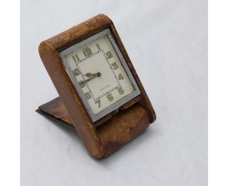 A Le Coultre 'Eight Days' travel alarm clock, the rectangular white dial with Arabic numerals denoting hours and the tan leat