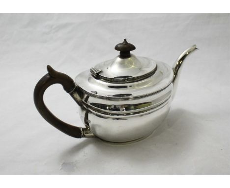 A silver teapot by Charles Stuart Harris with stained fruitwood handle and finials. Hallmarked London 1902. Gross weight appr