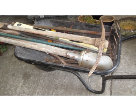 Wheelbarrow containing various tools to include pick axe, spade, spirit level, saws, post hole digger, oils cans, rakes etc.(