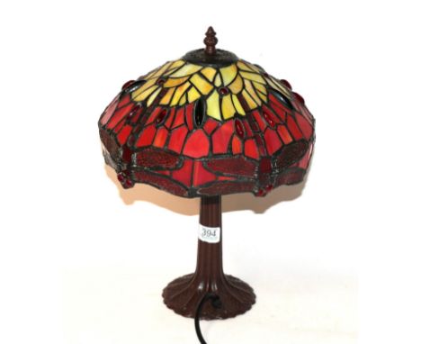 A Tiffany style table lamp decorated with dragonflies. Shade - 30cm wide, 15cm high. One pane to the rim (dragonfly wing) cra