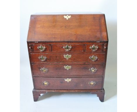 A SLENDER 19TH CENTURY OAK BUREAU, having fall down writing slope revealing well fitted interior, having three in-line drawer