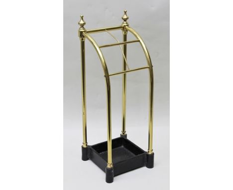 A BRASS STICK STAND with black painted cast metal base, fitted urn finial, 60cm high 