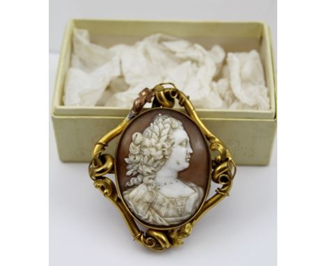 AN EARLY 19TH CENTURY GILT METAL MOUNTED SHELL CAMEO BROOCH, carved with a female bust, possibly Queen Charlotte, in a tubula
