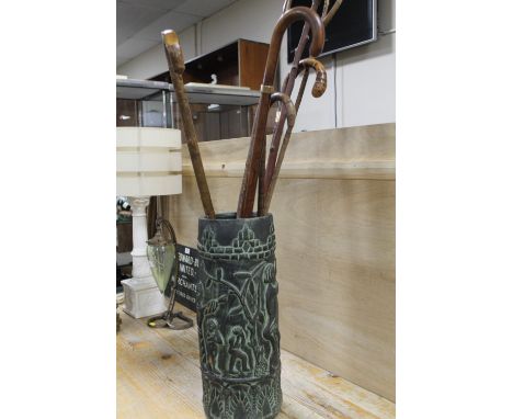 A SMALL COLLECTION OF WALKING STICKS IN A CERAMIC STAND