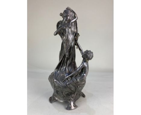 An Art Nouveau style pewter figural stand, possibly to hold a vase, depicting a semi-nude female figure and seated male figur