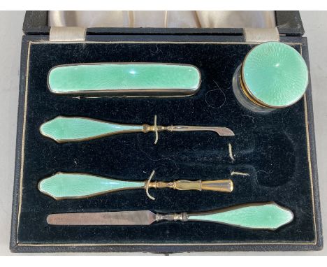 A cased five piece manicure set, (scissors missing) the green guilloche enamel on silver plate, (a/f) case 20cm wide
