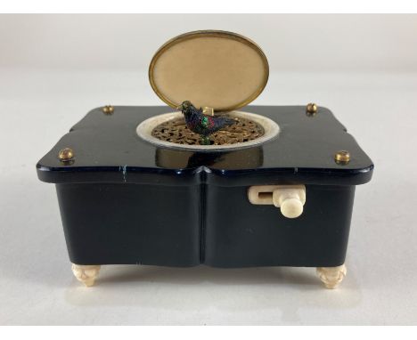 A 19th century singing bird automaton music box, the gilt and ivory lid opening to reveal a brightly coloured model of a bird