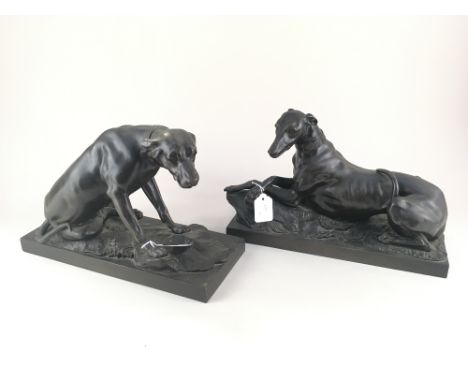 A pair of bronze models of dogs, a greyhound lying, and a pointer standing, both on integral rectangular base, 34cm, unsigned