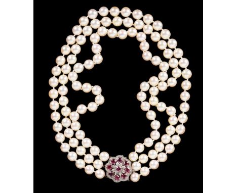 A TRIPLE STRAND CULTURED PEARL NECKLACE each pearl knotted, terminating in a 9ct white gold clasp set with a diamond and ruby
