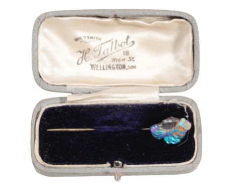 A CARVED BOULDER OPAL STICK PIN of an Indian chief's head, on an unmarked yellow metal pin