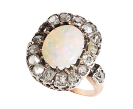 AN OPAL AND DIAMOND CLUSTER RING the central oval-cut opal with green/blue/red hues, within a border of old-cut diamonds, (on