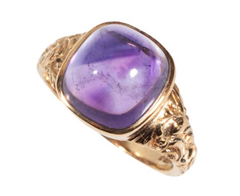 A CABOCHON AMETHYST DRESS RING on a 9ct yellow gold shank, with embossed shoulders, ring size U