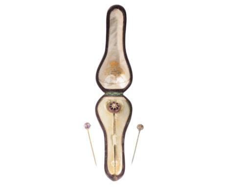 A VICTORIAN ENAMEL AND PEARL STICK PIN mounted on unmarked yellow metal, together with two other stick pins, in a fitted pres
