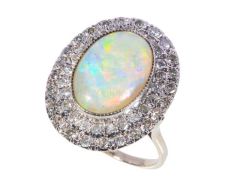 AN OPAL AND DIAMOND CLUSTER RING the central opal with green and pink hues, collet-set within a double border of brilliant-cu