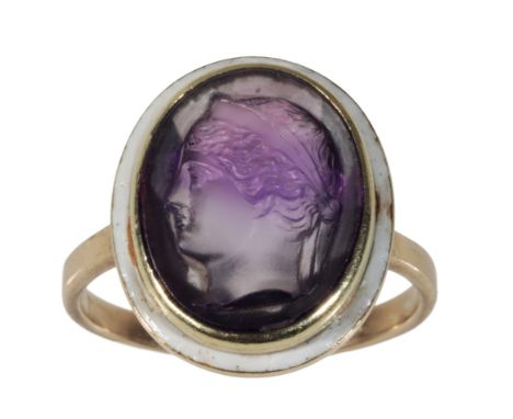 AN AMETHYST AND ENAMEL DRESS RING the amethyst carved with the profile of a lady's head, within an enamel border, on  a 9ct y