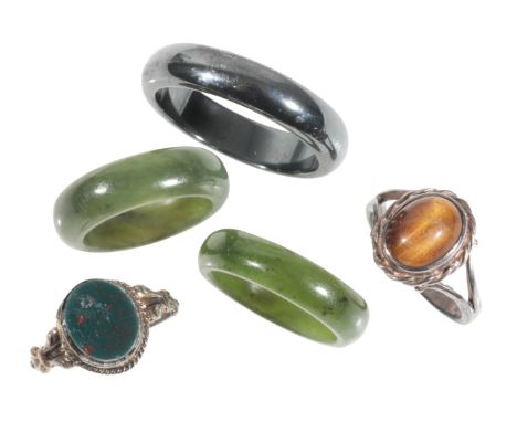 TWO JADEITE RINGS together with a hematite ring, a silver tigers eye ring, and a silver bloodstone ring (5)