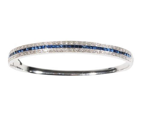 A SAPPHIRE AND DIAMOND BANGLE half-set with sapphires and diamonds in white gold, the clasp stamped "14K" (c.14.3grams total 