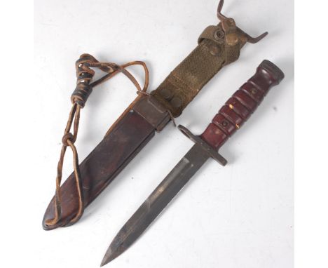 A U.S. M4 knife bayonet, having a 16.5cm double edged blade, steel muzzle ring and ribbed two piece wooden grip, in an M8A1 s