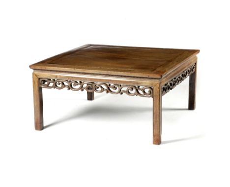 A CHINESE PADOUK KANG TABLE LATE 19TH CENTURY the panelled top above a plain frieze and a pierced and carved apron of interlo