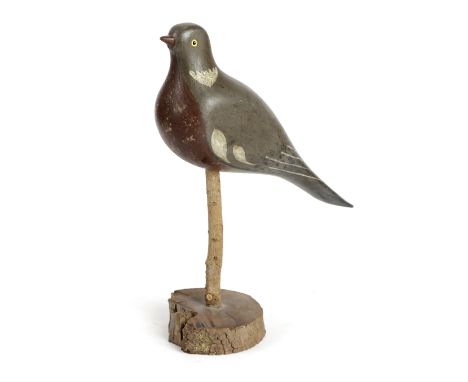 A FOLK ART CARVED AND PAINTED PINE DECOY PIGEON FIRST HALF 20TH CENTURY with glass eyes, mounted on a rustic wood base 30cm h